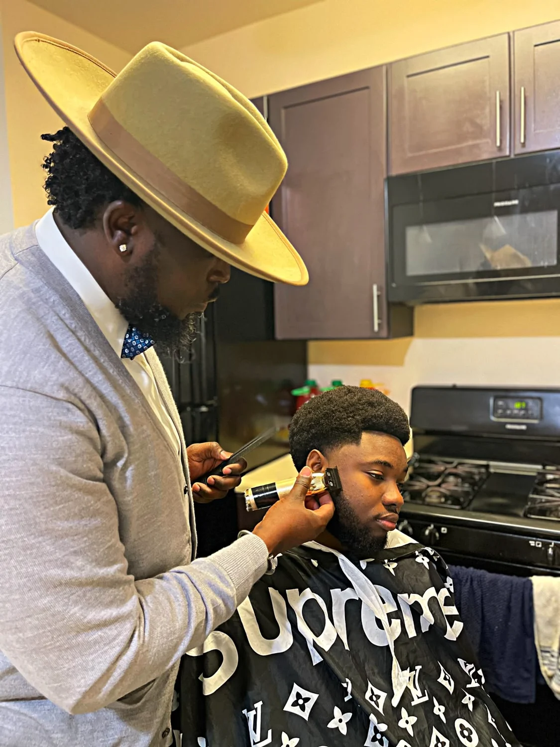 Rece at work cutting a client's hair
